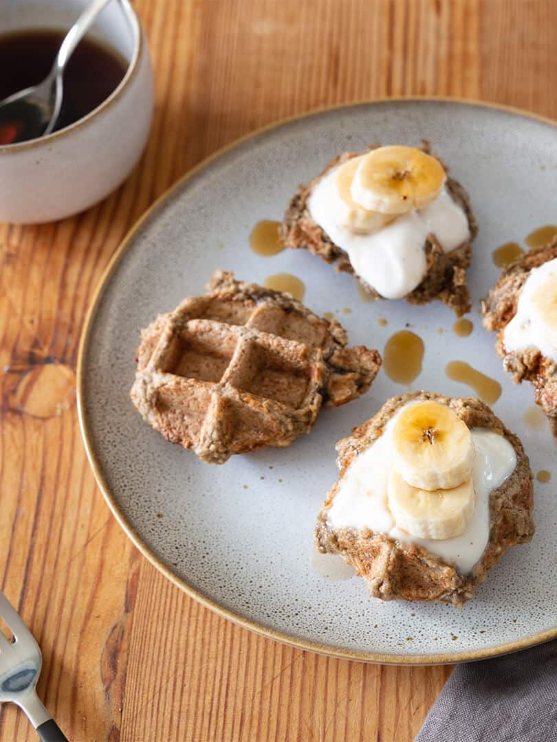 Vegan oat waffles with banana and maple syrup.