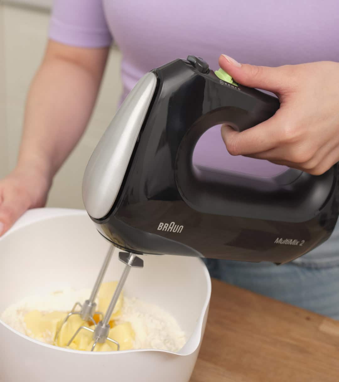 Woman mixing  dough with a black Braun MultiMix 2 Hand mixer