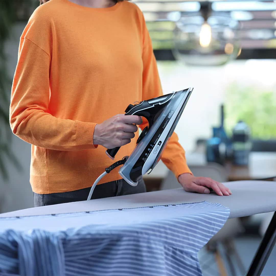 Person ironing a shirt with a Braun FreeStyle 5